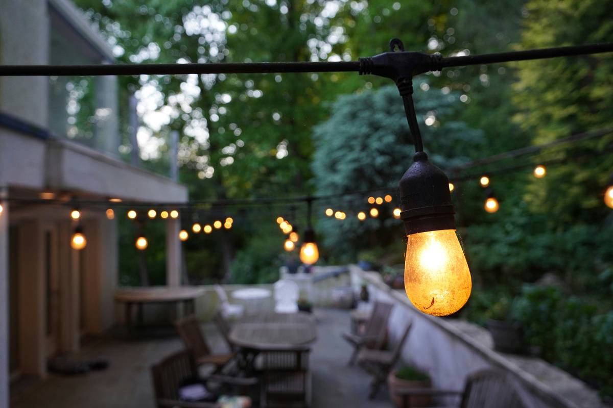 Outdoor patio decorated with string lights fun diy setup using removable hooks and warm white LEDs